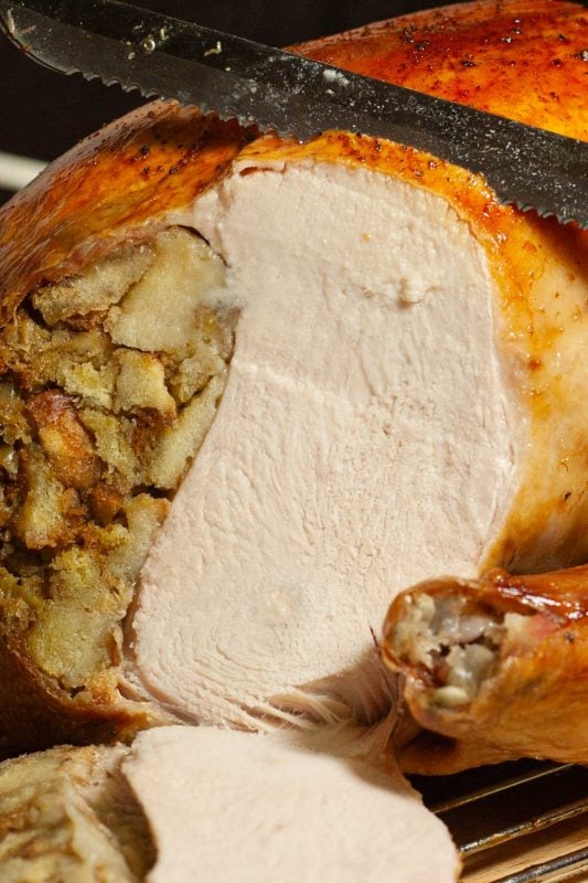Roast turkey filled with stuffing being carved.
