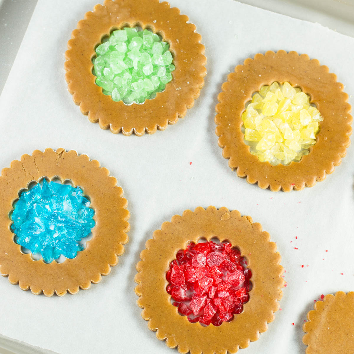 Gingerbread dough cut into circle shapes, center filled with crushed candy.