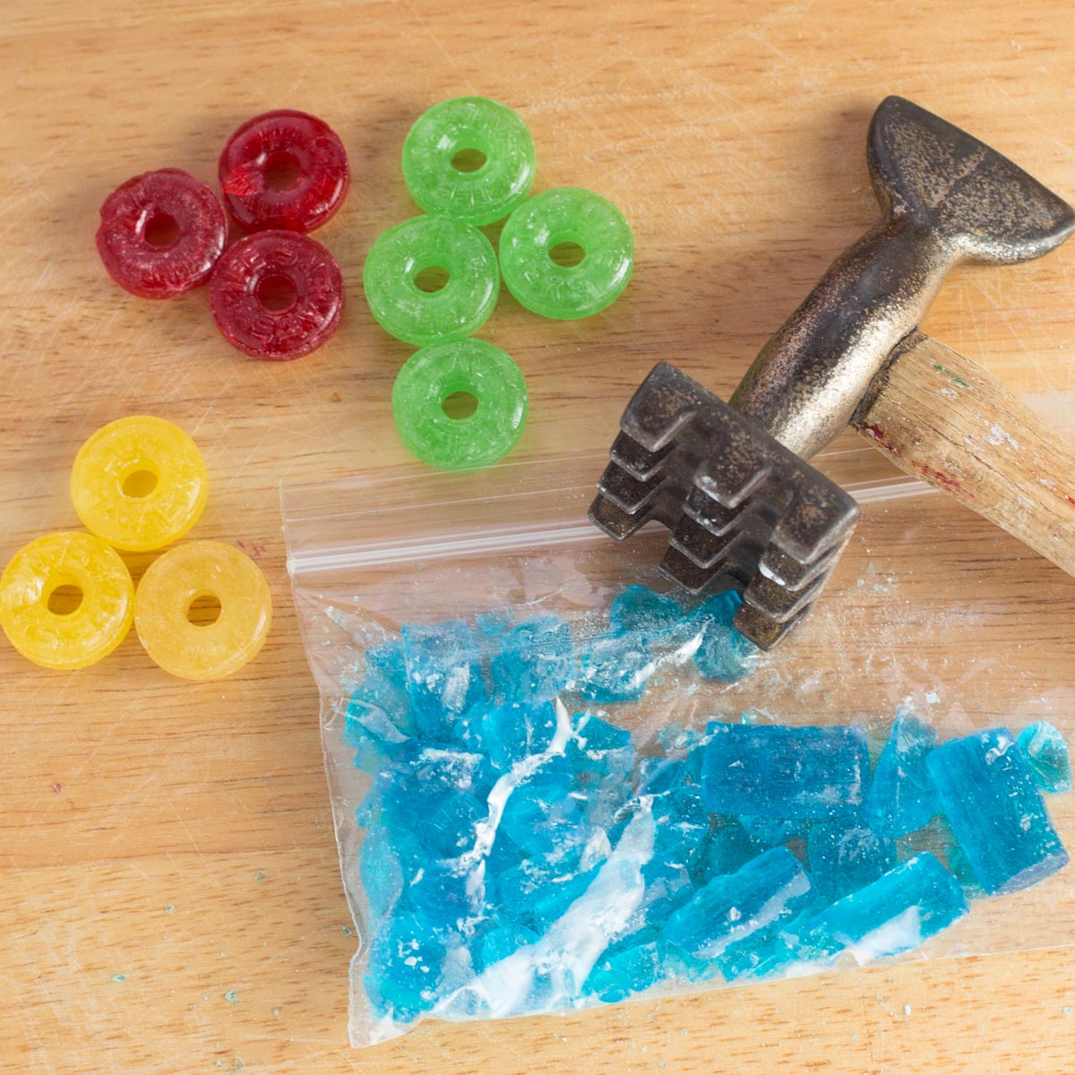 Colorful hard candy with mallet. Blue candies in crushed in plastic bag.
