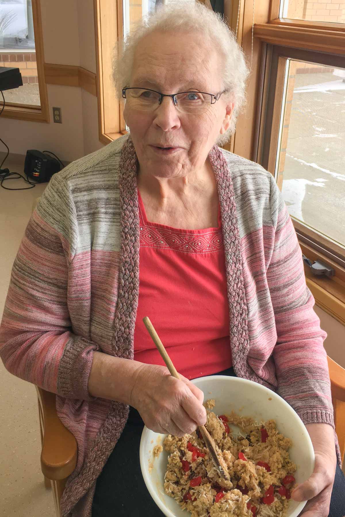 Senior woman holding bowl of cookie dough.