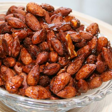 Bowl of roasted almonds coated in a glaze of honey and spices.