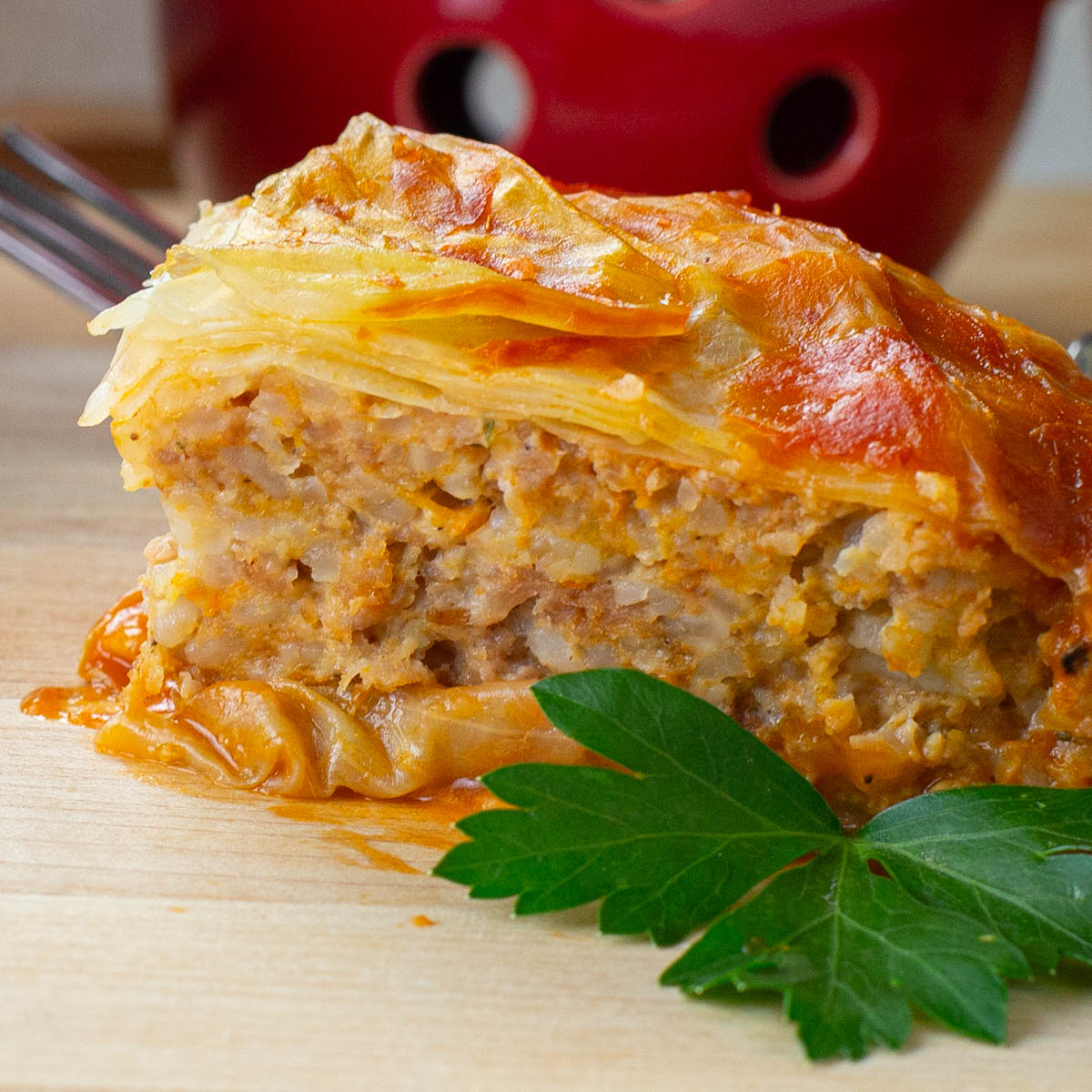 Portion of baked turkey cabbage roll casserole on wood board.