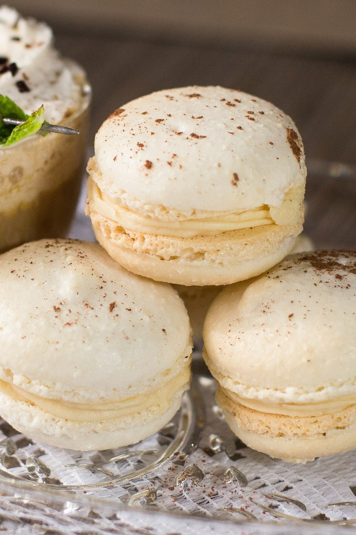 Stack of three Irish cream filled macaron cookies on glass plate.