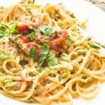 Plate of chicken and linguine tossed in creamy sauce, topped with salsa and cilantro.