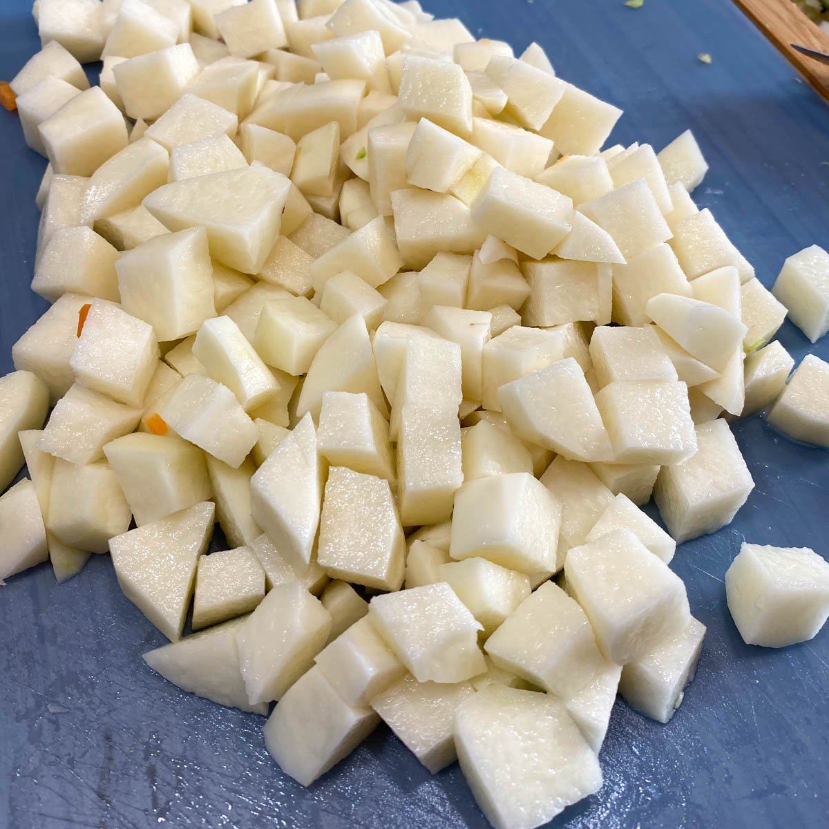 Chopped potatoes scattered on a cutting board.
