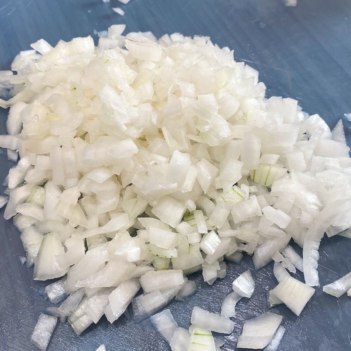 Diced onions scattered on a cutting board.