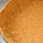 Pie crust made with gingersnaps in a glass pie plate.