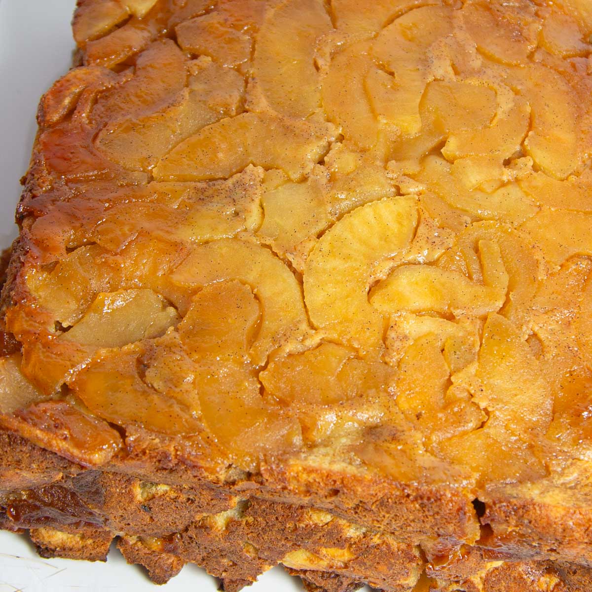Golden-brown upside-down apple bread pudding with a layer of caramelized apple slices on top.