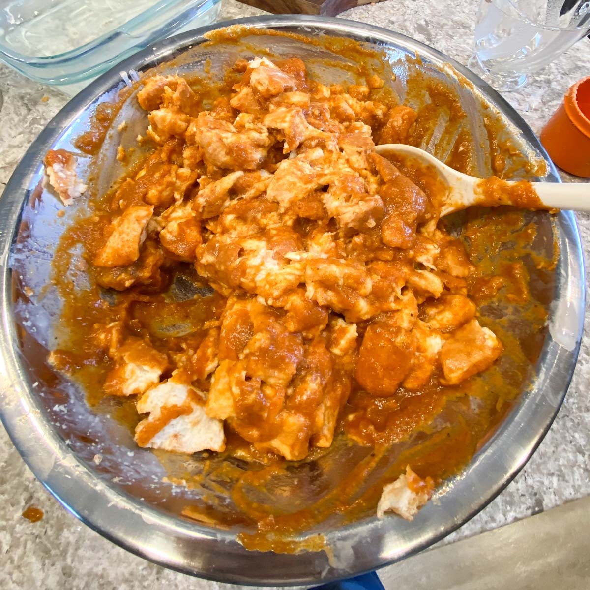 A metal bowl with bread chunks coated in a rich, pumpkin filling.