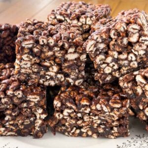Stack of puffed wheat squares on a white decorative plate.
