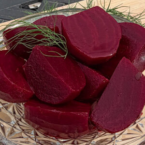 Cut up pickled beets in glass bowl, garnished with fresh dill sprigs.